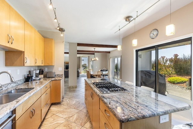 kitchen with a kitchen island, beam ceiling, light brown cabinetry, a sink, and appliances with stainless steel finishes