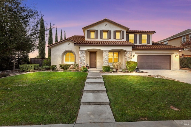 mediterranean / spanish home featuring fence, a tiled roof, stucco siding, a yard, and driveway