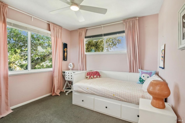 carpeted bedroom with multiple windows, a ceiling fan, and baseboards