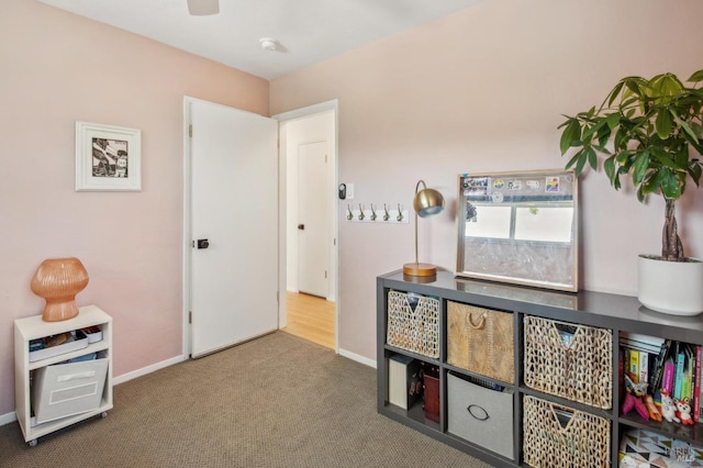 interior space with baseboards, carpet floors, and a ceiling fan