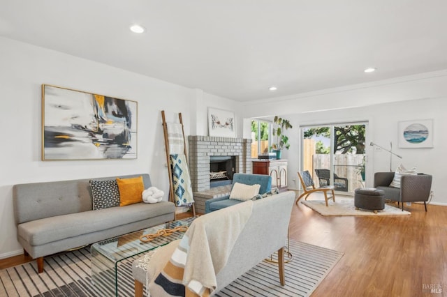 living area with a brick fireplace, recessed lighting, wood finished floors, and baseboards