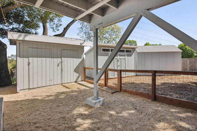 view of yard featuring fence, an outdoor structure, and a shed