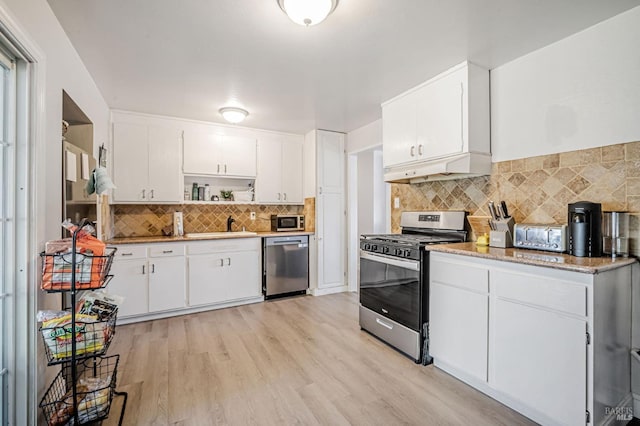 kitchen featuring appliances with stainless steel finishes, tasteful backsplash, open shelves, white cabinets, and light wood-style floors