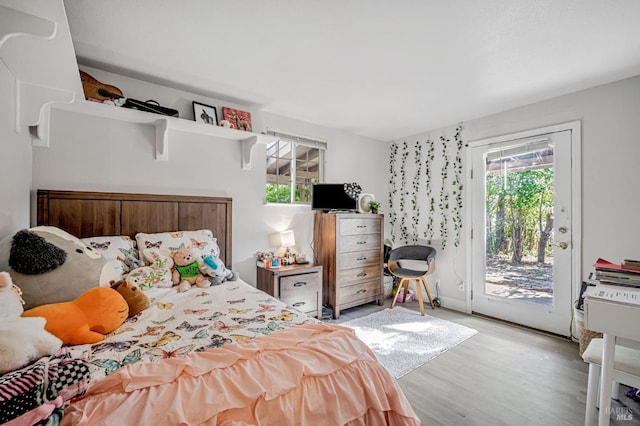 bedroom with access to exterior and light wood-style floors