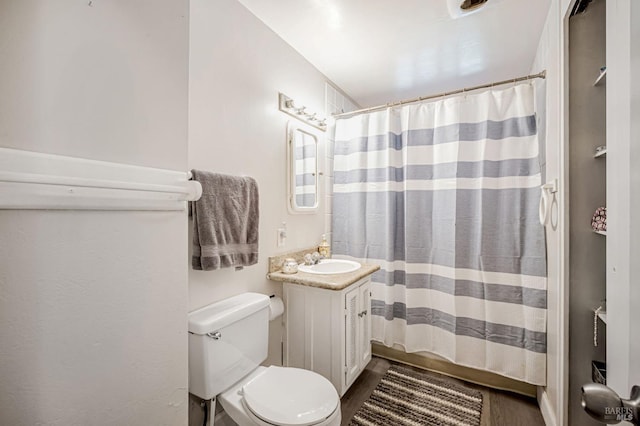 full bath with toilet, a shower with curtain, wood finished floors, and vanity