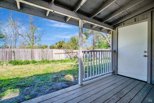 wooden terrace featuring a fenced backyard and a yard