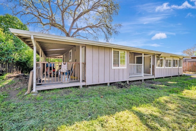 exterior space with a lawn, fence, and a wooden deck