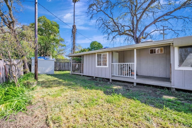 rear view of property featuring a fenced backyard, an outbuilding, a yard, and a storage shed