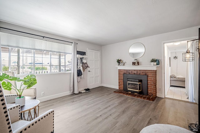 living area featuring baseboards, wood finished floors, and a fireplace