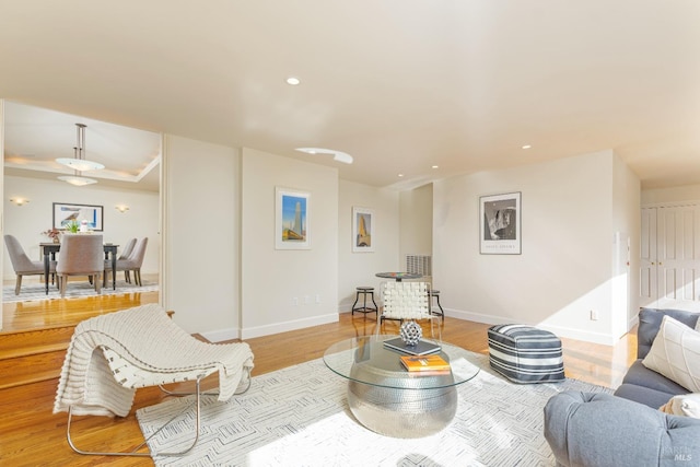 living area with recessed lighting, light wood-type flooring, and baseboards