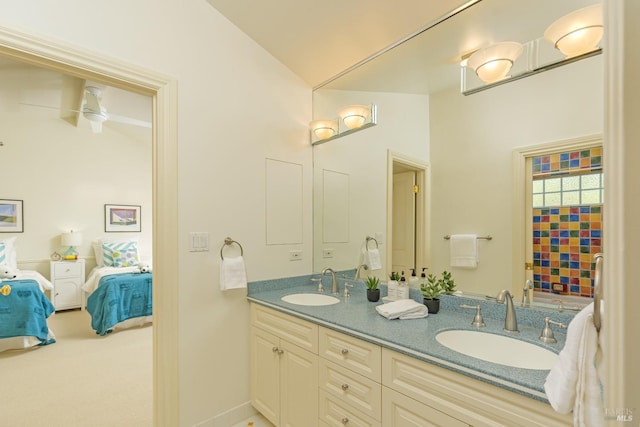 ensuite bathroom featuring ensuite bath, vaulted ceiling, double vanity, and a sink