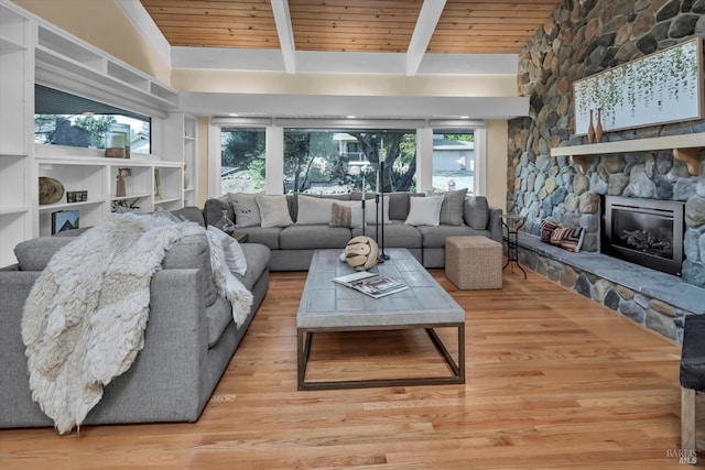 living area with beam ceiling, wood ceiling, wood finished floors, and a fireplace