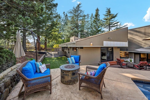 view of patio featuring an outdoor living space with a fire pit and fence