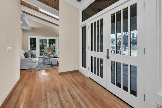 interior space featuring light wood finished floors, recessed lighting, vaulted ceiling with beams, and baseboards