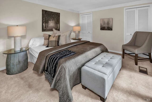 bedroom featuring carpet, baseboards, and two closets