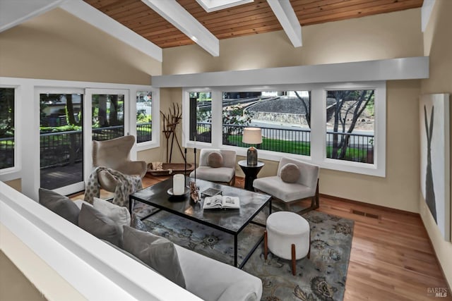 living room featuring lofted ceiling with skylight, visible vents, wooden ceiling, and wood finished floors