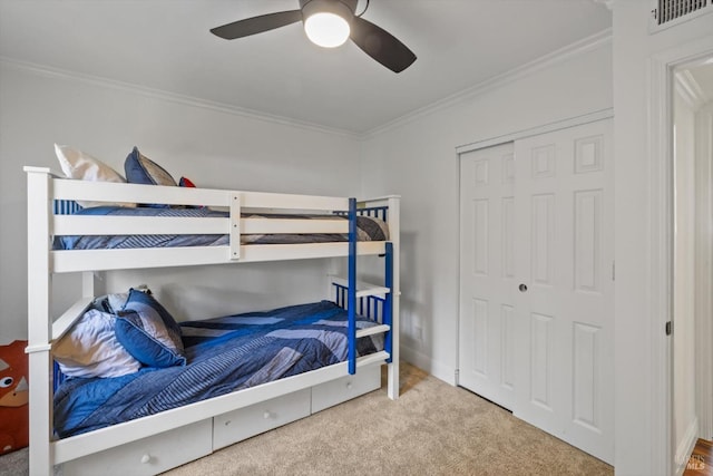 bedroom with carpet flooring, visible vents, a closet, and crown molding