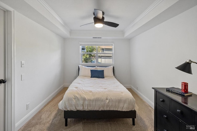 bedroom with light colored carpet, a raised ceiling, and baseboards