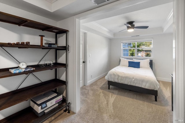 carpeted bedroom with baseboards, visible vents, a raised ceiling, and ornamental molding