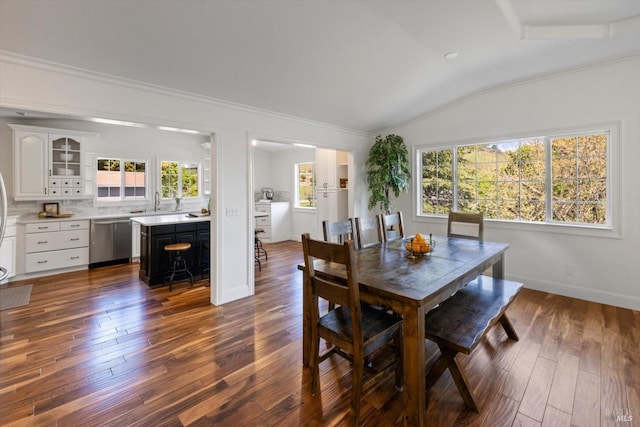 dining room with crown molding, baseboards, lofted ceiling, and dark wood-type flooring