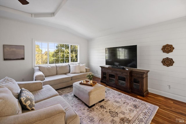 living area featuring lofted ceiling, wooden walls, wood finished floors, and baseboards