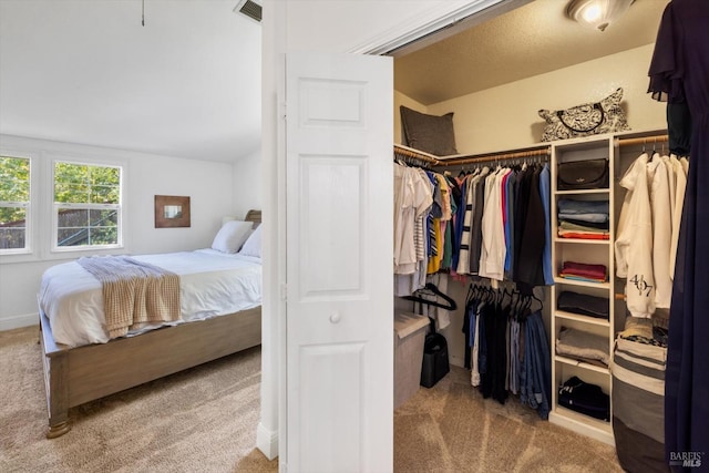 carpeted bedroom featuring a closet and visible vents
