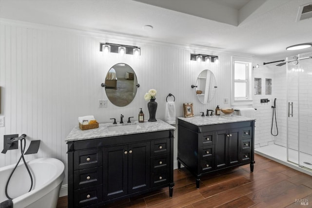 248 Vine St, Vacaville, CA 95688 - bathroom featuring a shower stall, two vanities, wood finished floors, and a freestanding bath