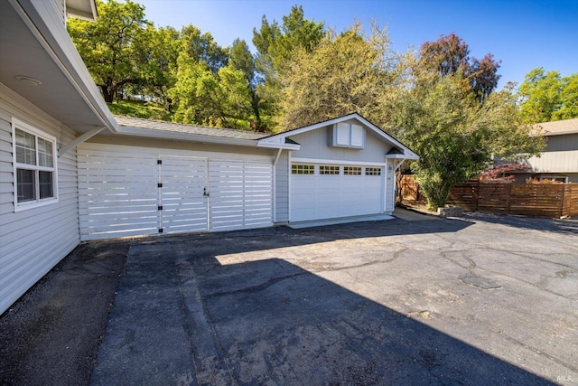 detached garage featuring fence