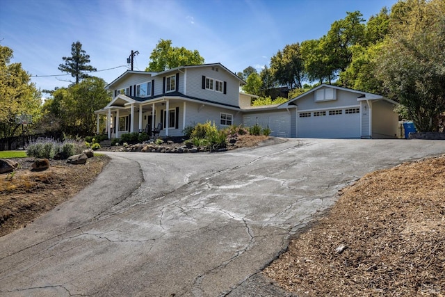 view of front of property with a garage, a porch, and driveway