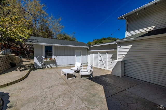 view of patio / terrace with an outdoor structure and fence