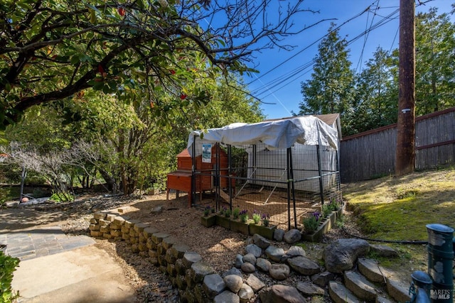 view of yard featuring fence, an outdoor structure, and exterior structure