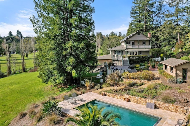 back of property featuring fence, an outdoor pool, stairs, a patio area, and a lawn