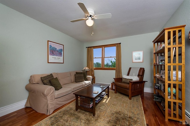 living room featuring baseboards, a ceiling fan, and wood finished floors