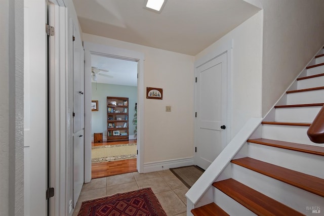 entrance foyer featuring stairway, ceiling fan, and light tile patterned flooring