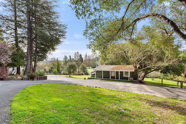 view of front of home with aphalt driveway and a front lawn