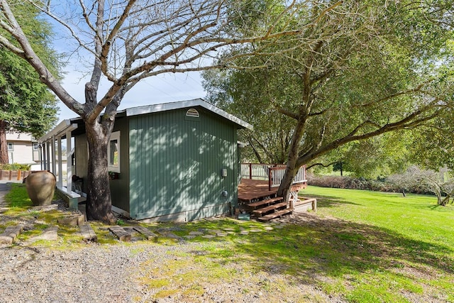 view of side of property with a yard and a deck