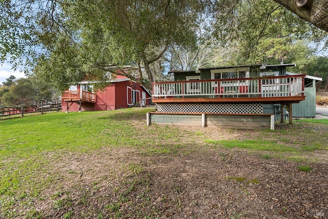 back of house featuring a yard and a wooden deck