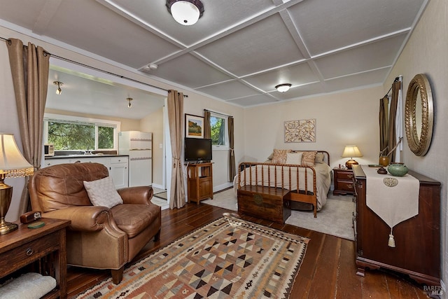 bedroom featuring wood-type flooring, a sink, freestanding refrigerator, and coffered ceiling