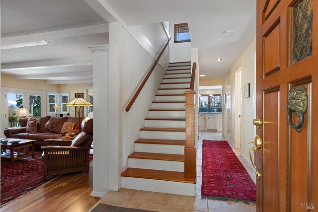 stairway with beamed ceiling and recessed lighting