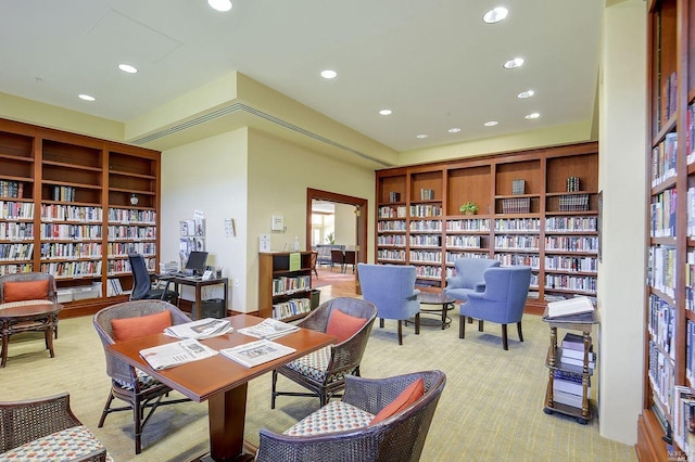 interior space with light carpet, recessed lighting, bookshelves, and built in features