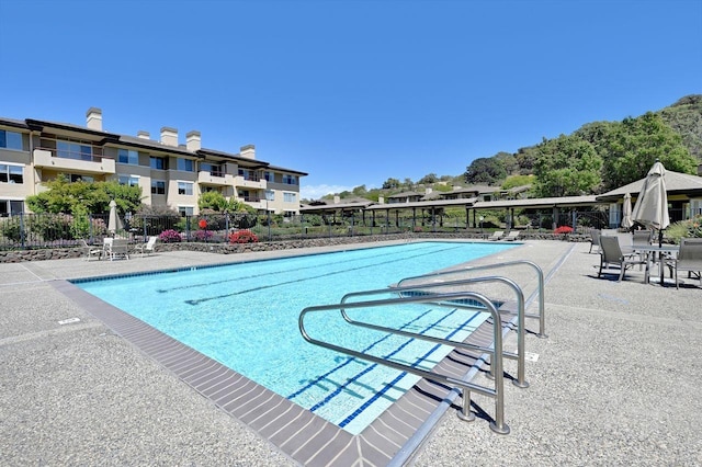 community pool featuring a patio area and fence