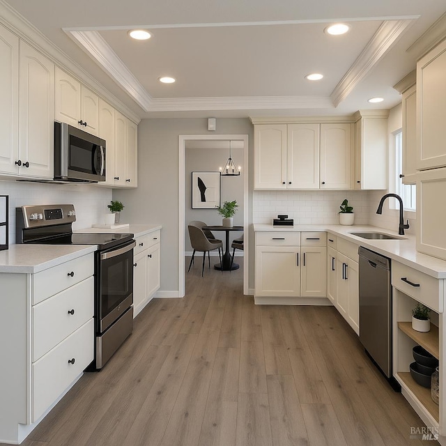 179 Midvale Dr, Vacaville, CA 95687 - kitchen with appliances with stainless steel finishes, a raised ceiling, ornamental molding, decorative backsplash, and light wood-type flooring