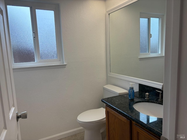 bathroom with baseboards, toilet, and vanity