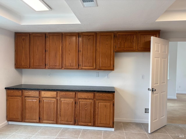 kitchen featuring brown cabinets, visible vents, and baseboards