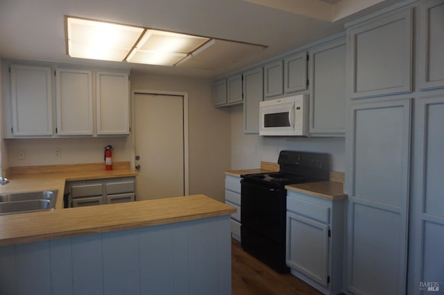 237 Sunflower Ct, Fairfield, CA 94533 - kitchen with white microwave, black range with electric cooktop, a sink, a peninsula, and dark wood finished floors