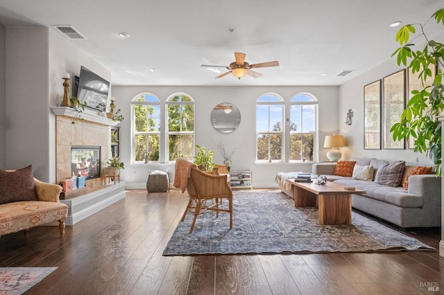 living area featuring hardwood / wood-style floors, plenty of natural light, ceiling fan, and visible vents