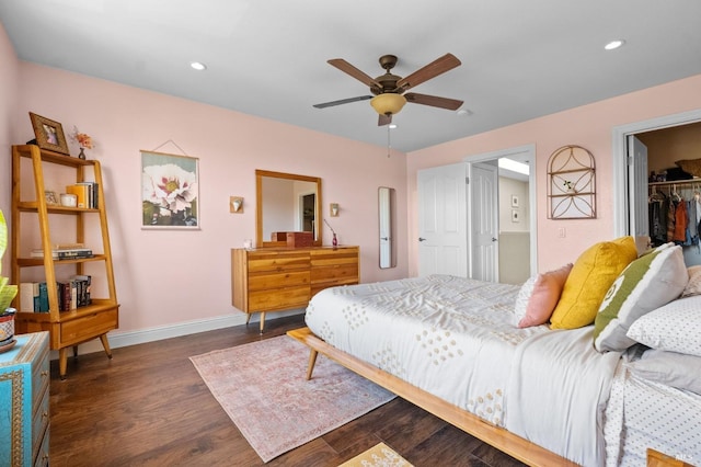bedroom with baseboards, a walk in closet, recessed lighting, and dark wood-type flooring