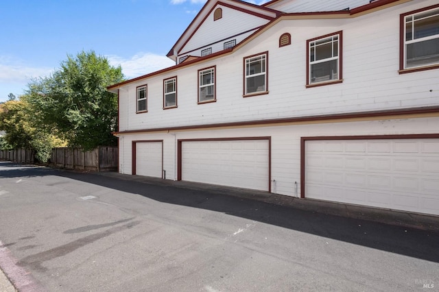 view of home's exterior with fence and an attached garage