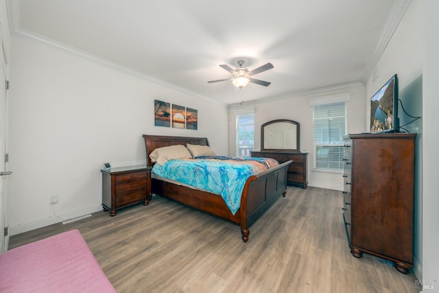bedroom featuring baseboards, a ceiling fan, light wood-style flooring, and crown molding