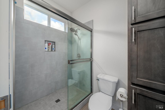 bathroom featuring a shower stall and toilet